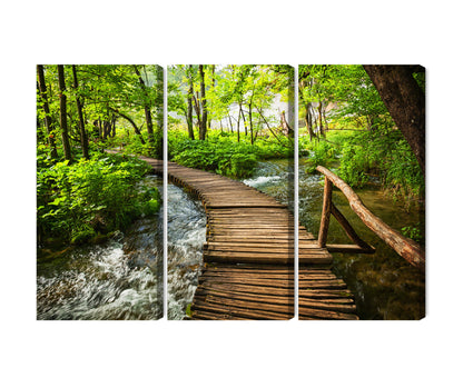 Obraz Wieloczęściowy Drewniana Kładka w Lesie – spokojna panorama natury do wnętrz skandynawskich i boho – 3 równe części (60x40–180x120 cm) – układ paneli