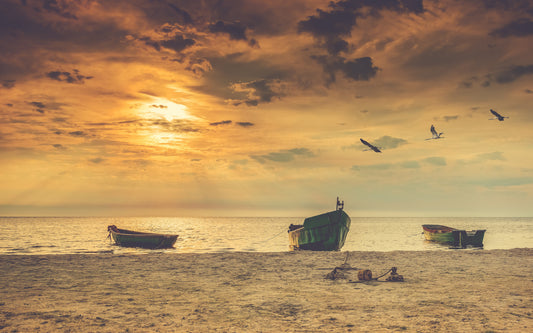 Obraz Wieloczęściowy Łodzie na Plaży – zachód słońca do wnętrz nadmorskich, boho i nowoczesnych 240x150