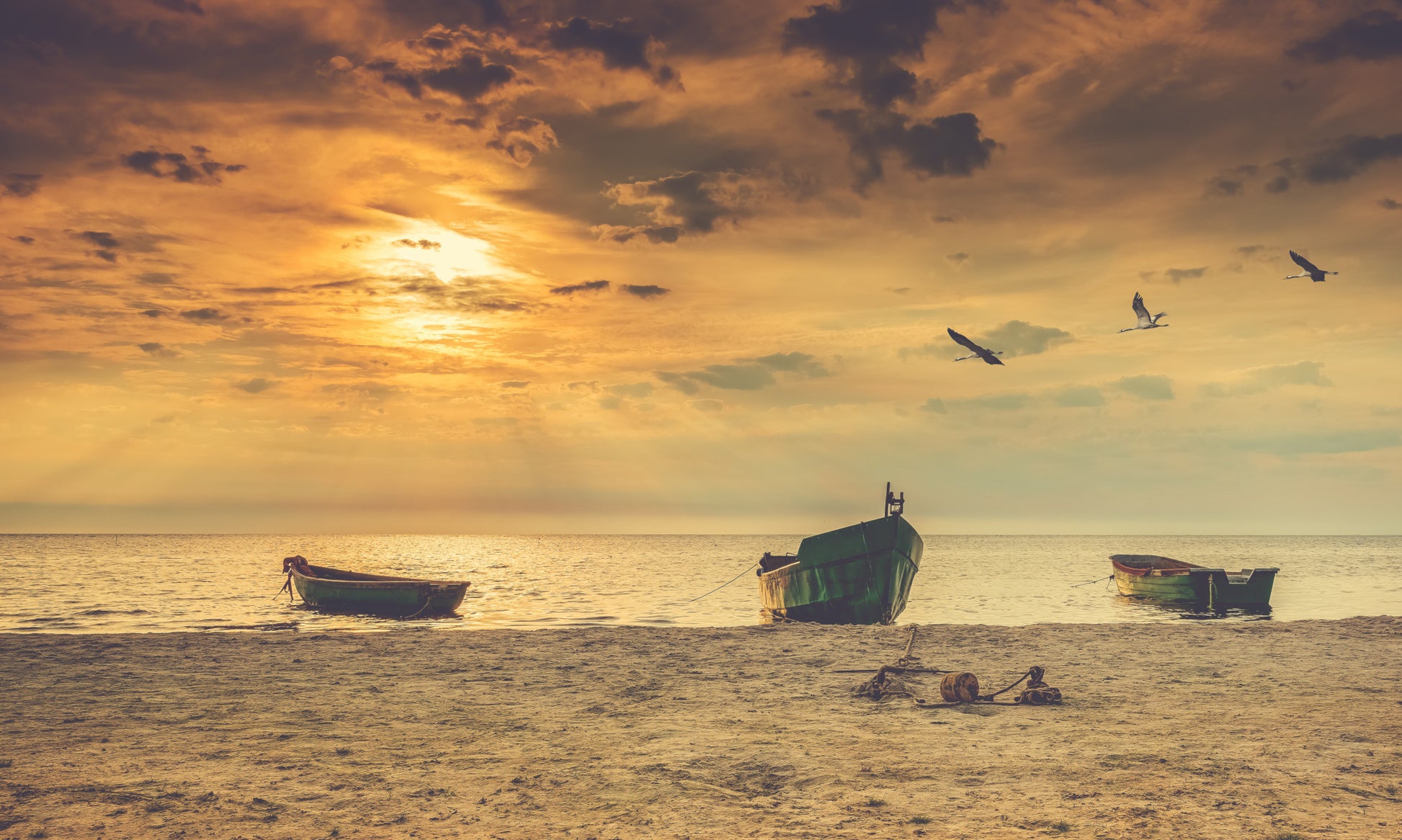 Obraz Wieloczęściowy Łodzie Na Plaży – nastrojowa panorama zachodu słońca do wnętrz boho, nowoczesnych i nadmorskich 250x150