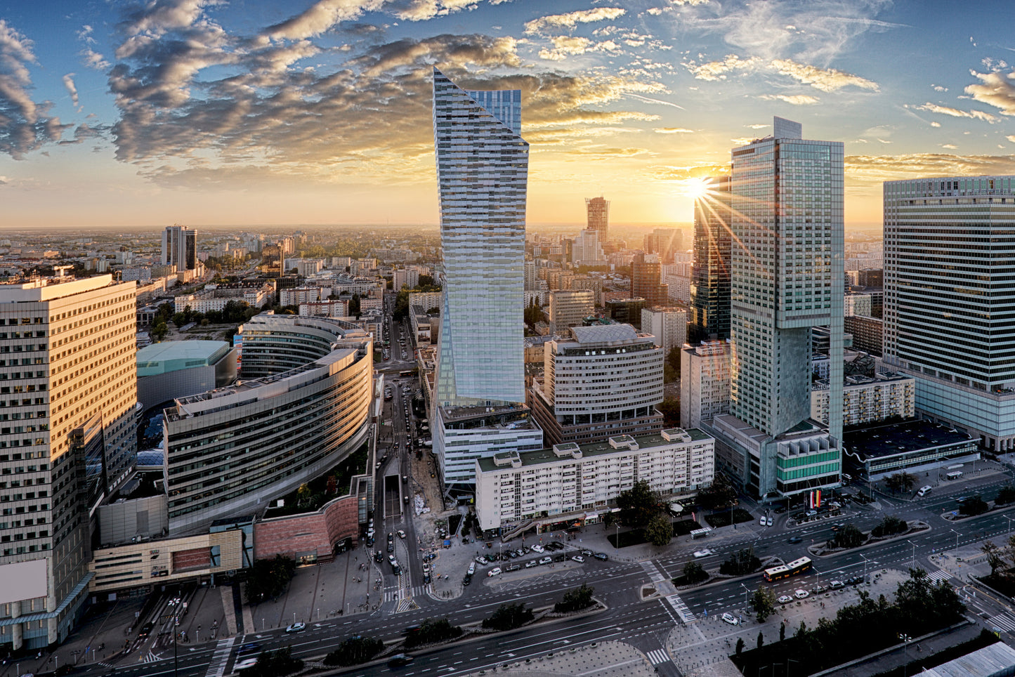 Obraz Wieloczęściowy Warszawskie Wieżowce – złocisty zachód słońca do wnętrz nowoczesnych, loftowych i industrialnych 180x120