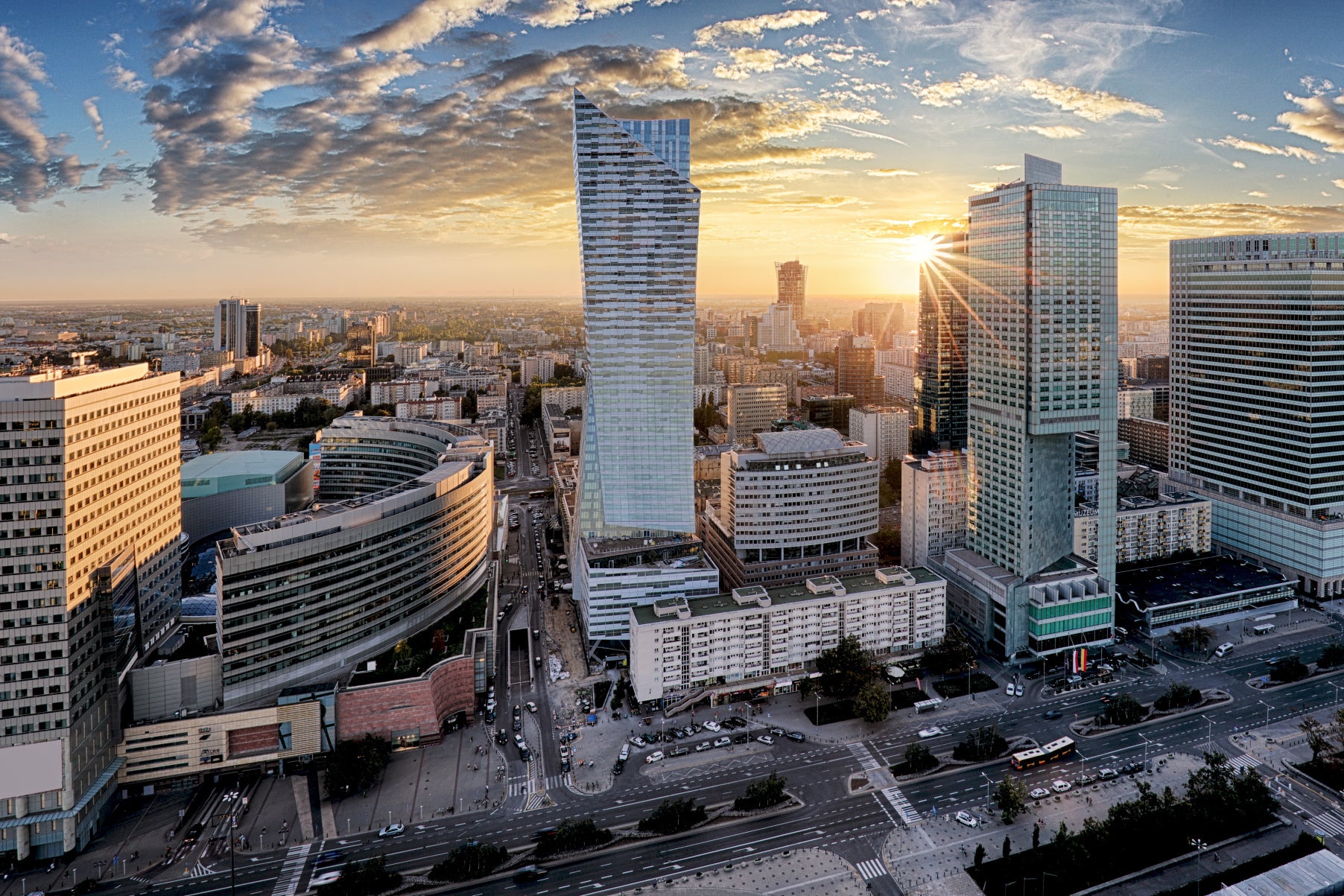 Obraz Wieloczęściowy Warszawskie Wieżowce – złocisty zachód słońca do wnętrz nowoczesnych, loftowych i industrialnych 180x120