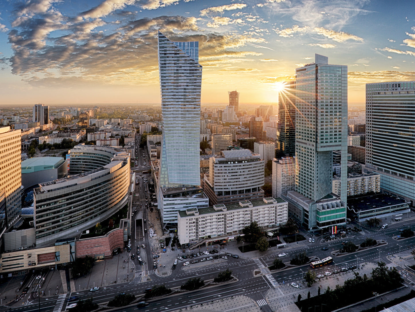 Obraz Wieloczęściowy Warszawskie Wieżowce – miejska panorama o zachodzie słońca do wnętrz nowoczesnych i industrialnych 200x150