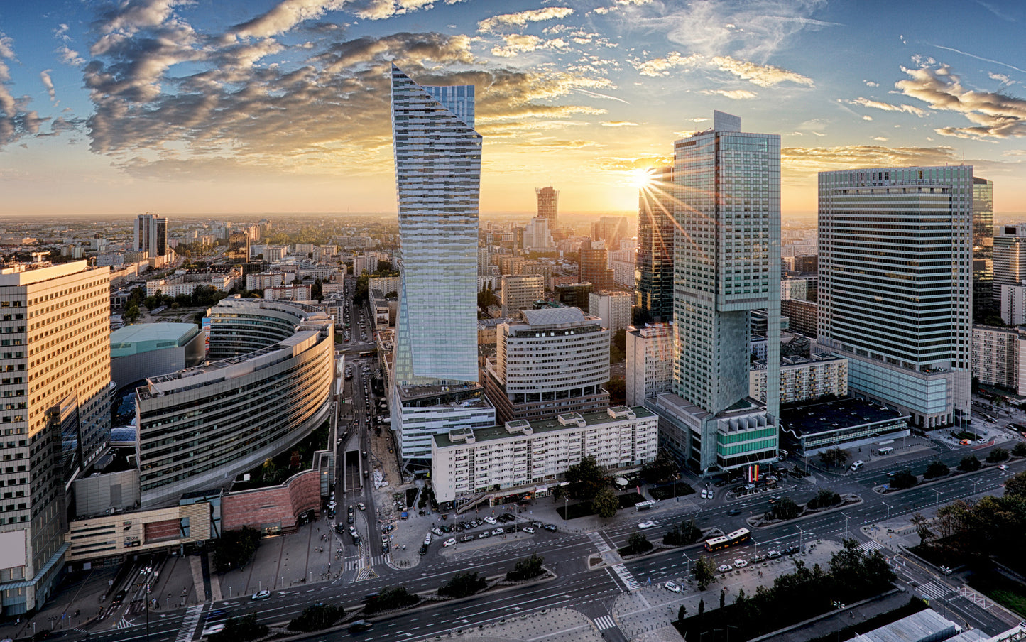Obraz Wieloczęściowy Warszawskie Wieżowce – miejski pejzaż o zachodzie słońca do wnętrz nowoczesnych, industrialnych i loftowych 240x150